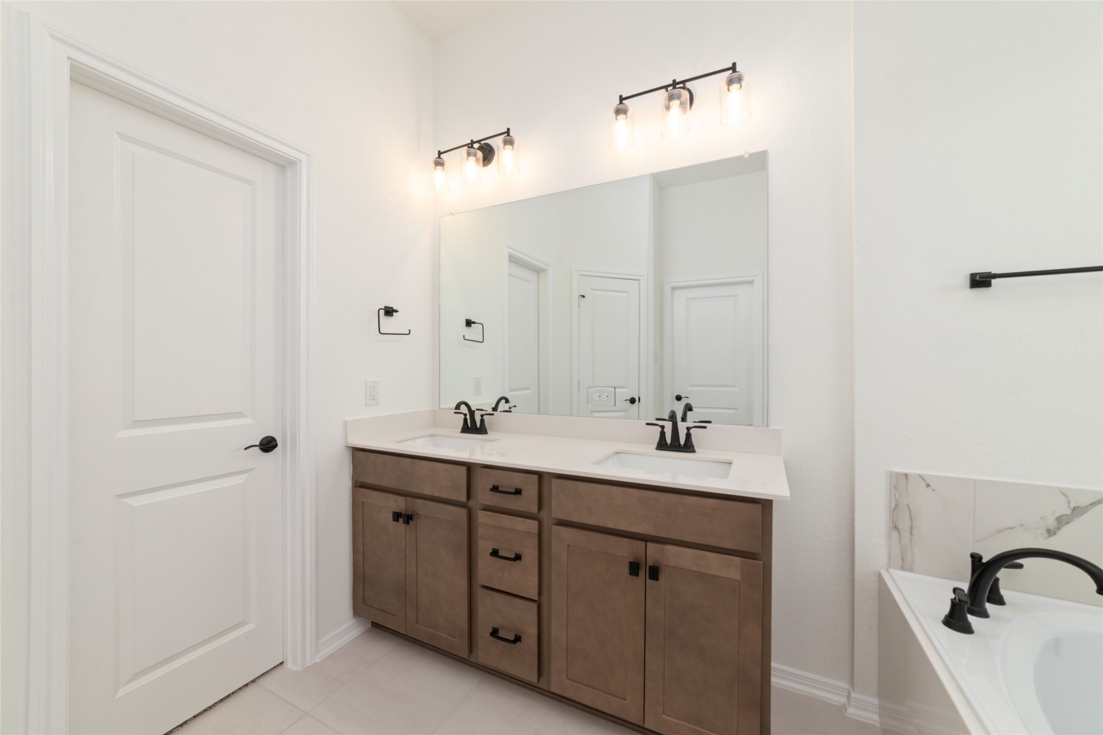 135 East Coralburst Loop, Unit 1 Montgomery, TX 77316 - Photo 16 of 22 a bathroom with a double vanity sink a mirror and a bathtub
