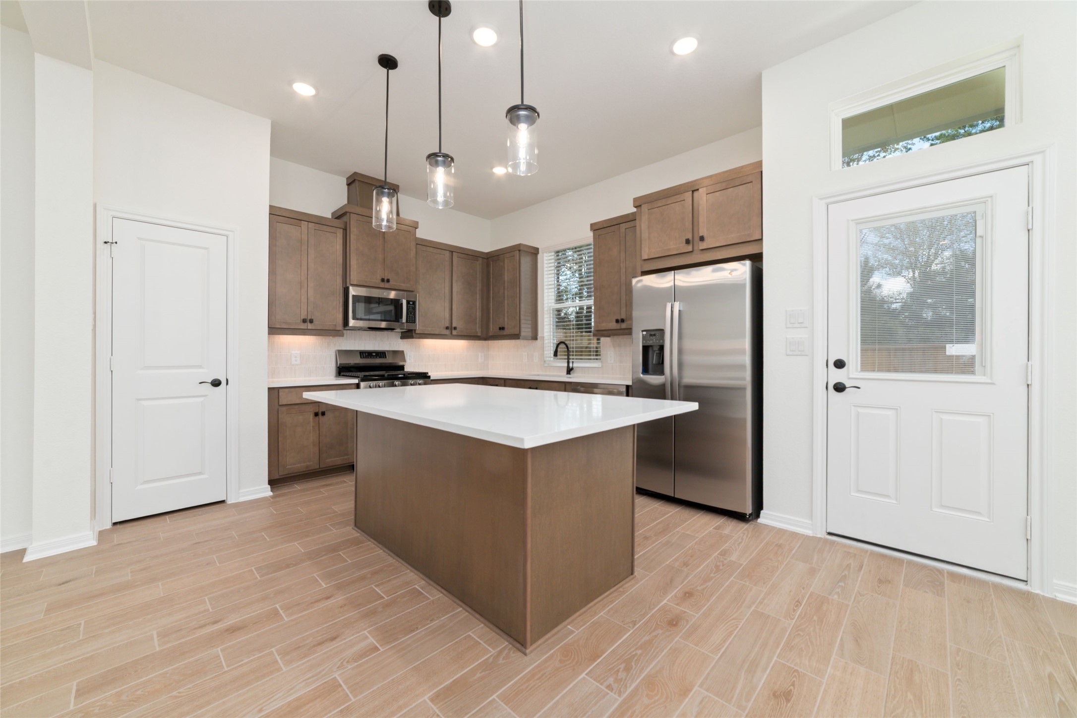 135 East Coralburst Loop, Unit 1 Montgomery, TX 77316 - Photo 10 of 22 a kitchen with kitchen island a sink stainless steel appliances and cabinets