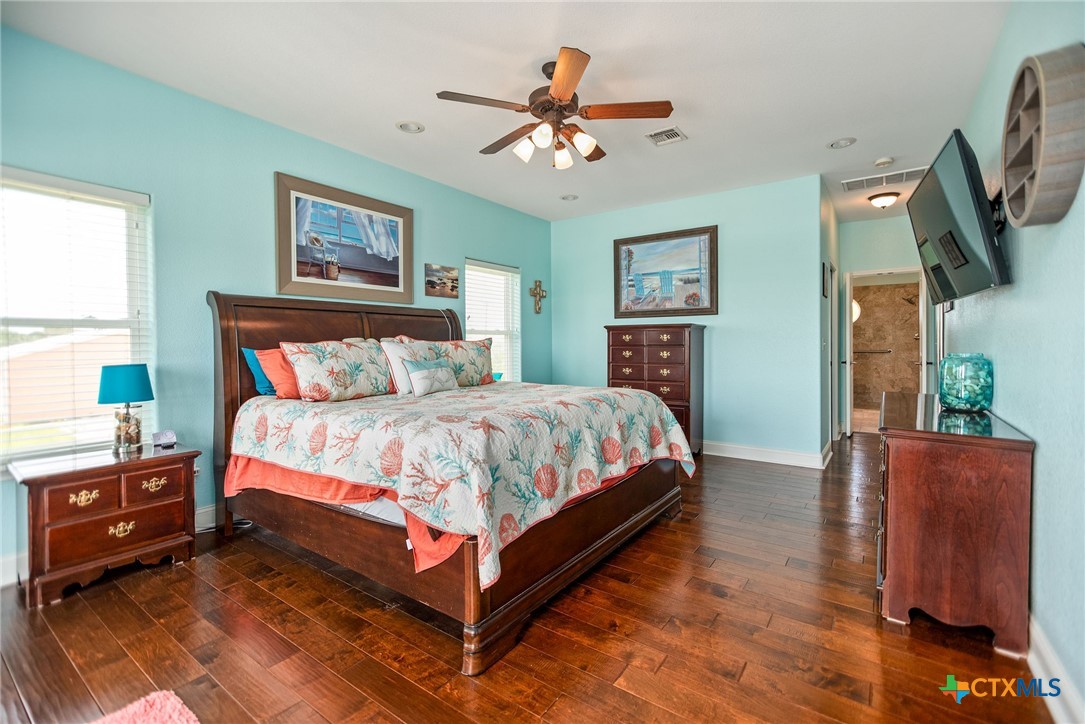 23 Macey Street Port O'Connor, TX 77982 - Photo 37 of 47 a bedroom with a bed and a dresser with wooden floor