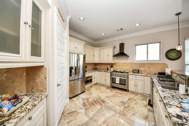 a kitchen with stainless steel appliances a stove a sink and a refrigerator