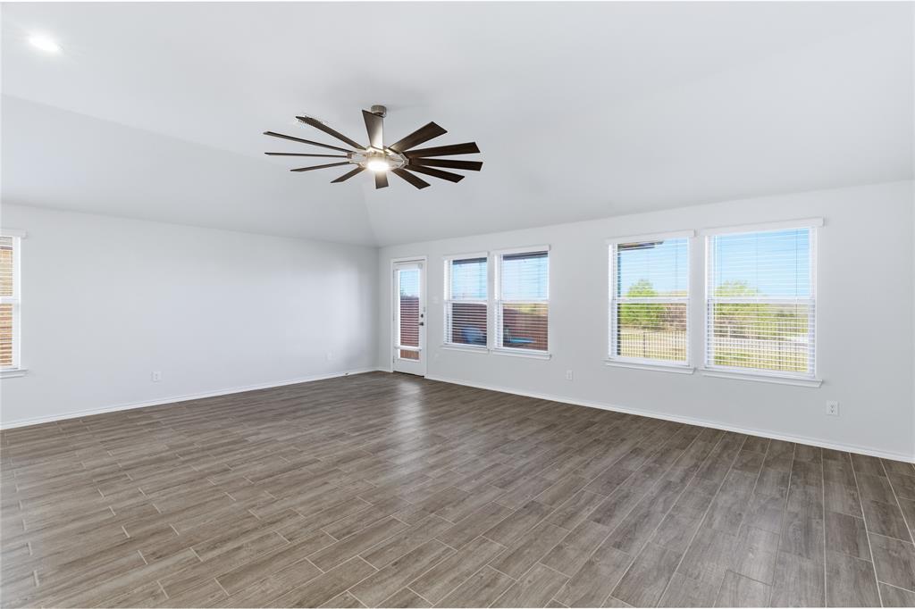 748 Ruellia Street Weatherford, TX 76086 - Photo 11 of 37 an empty room with wooden floor fan and windows