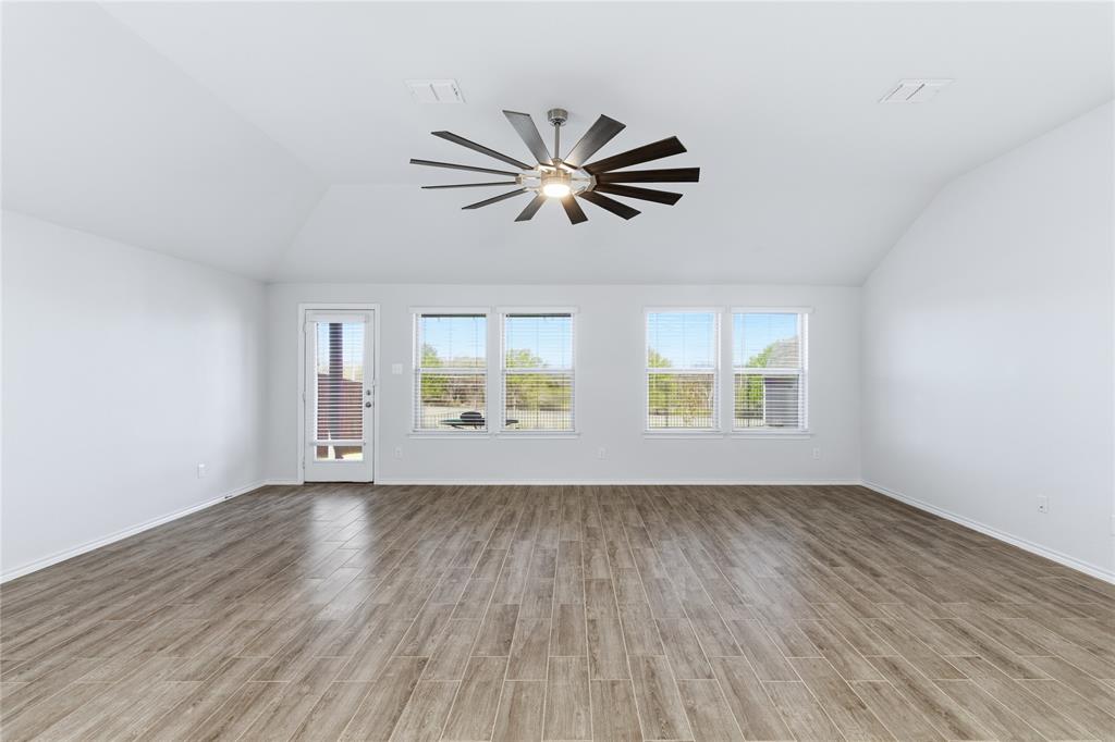 748 Ruellia Street Weatherford, TX 76086 - Photo 9 of 37 wooden floor in an empty room with a window