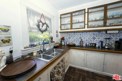 a bathroom with a granite countertop sink and a window