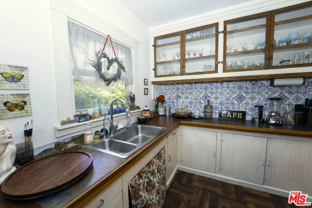 a bathroom with a granite countertop sink and a window