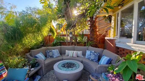 a view of patio with couches table and chairs and potted plants
