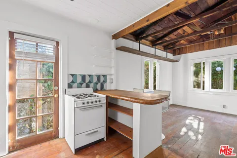 a kitchen that has a stove and a table in it