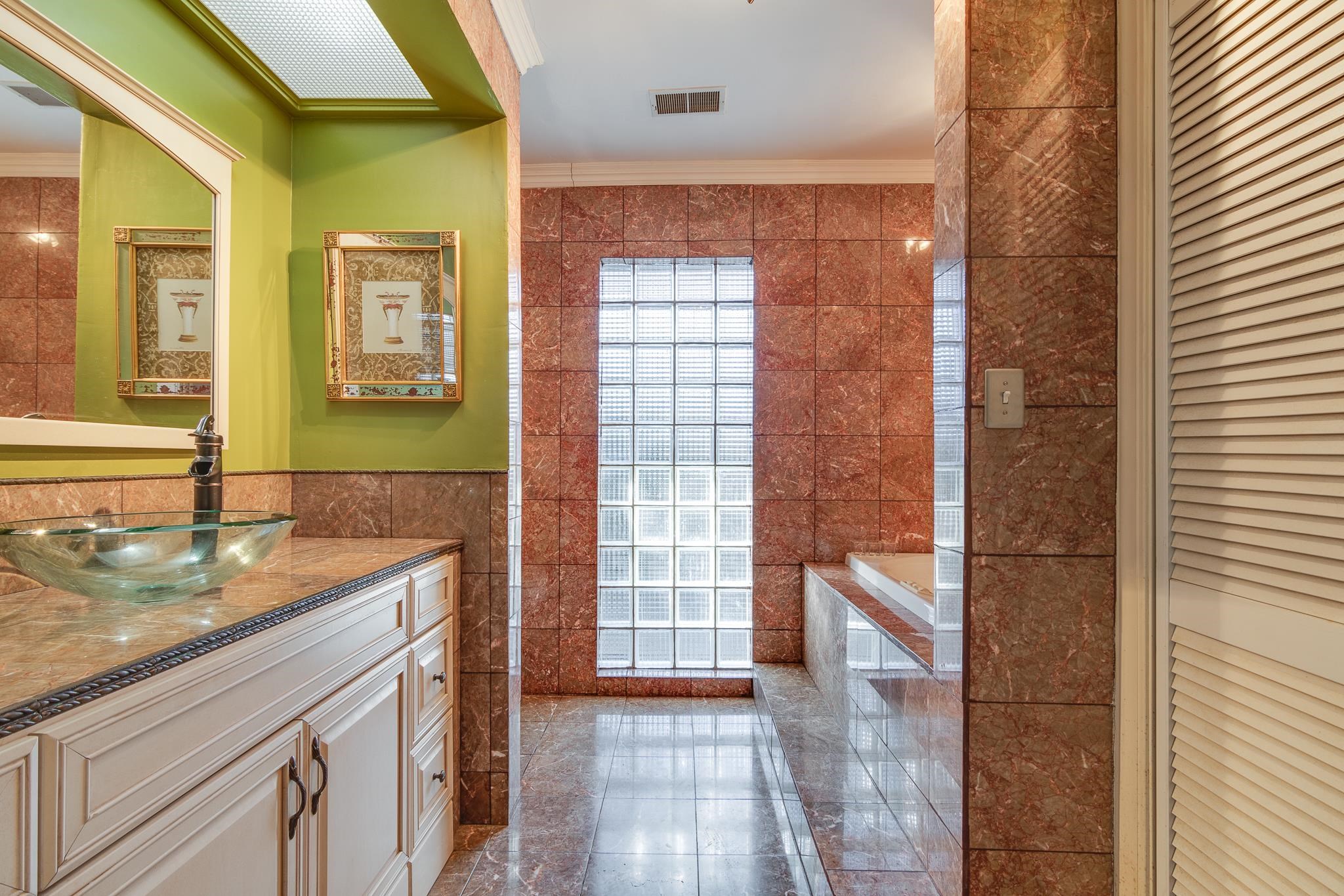 4926 Shady Grove Road Memphis, TN 38117 - Photo 15 of 23 a bathroom with a granite countertop sink a mirror and a shower