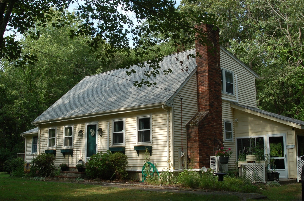 a front view of a house with a garden and plants