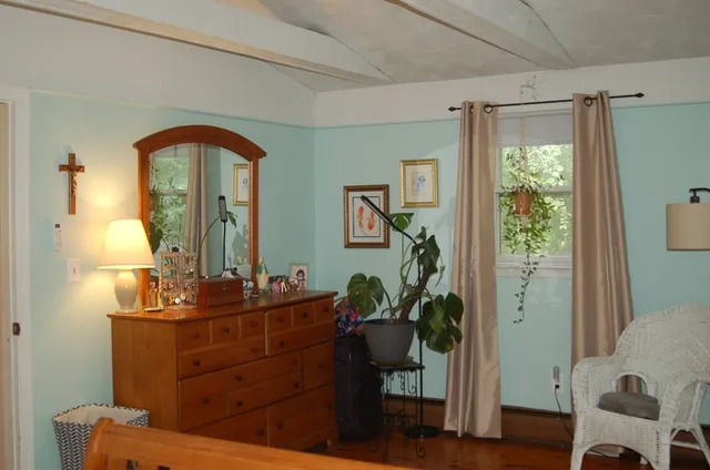 a bedroom with a bed and a lamp on the dresser