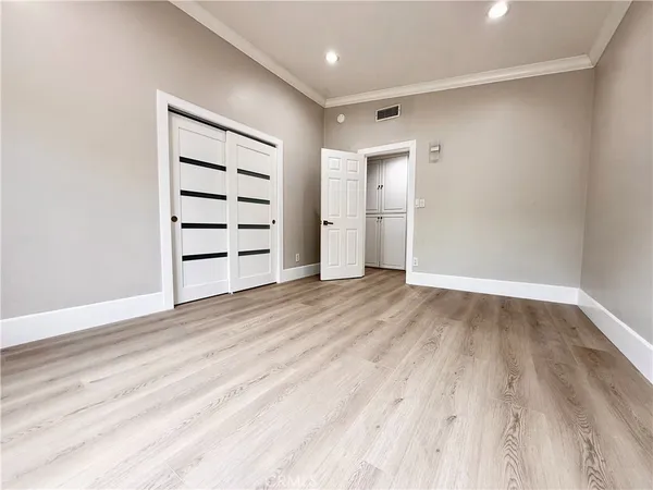 a view of a hallway with wooden floor and entryway