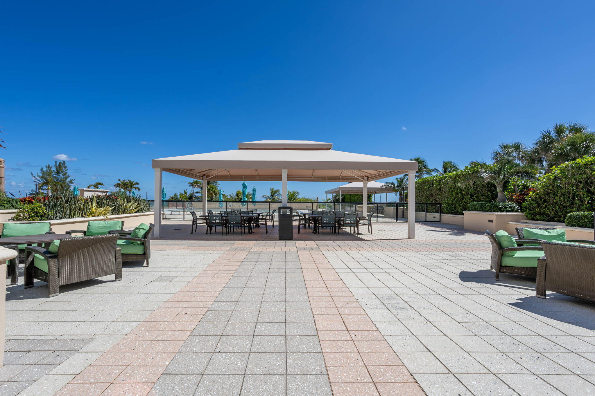 2000 South Ocean Boulevard, Unit 6K Boca Raton, FL 33432 - Photo 67 of 94 a view of a patio with dining table and chairs under an umbrella with a barbeque grill and plants
