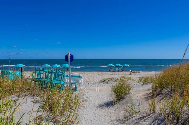 a view of a white house with a big yard and potted plants