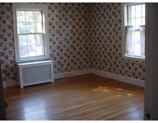 94 Reservation Road Milton, MA 02186 - Photo 7 of 9 an empty room with wooden floor and windows