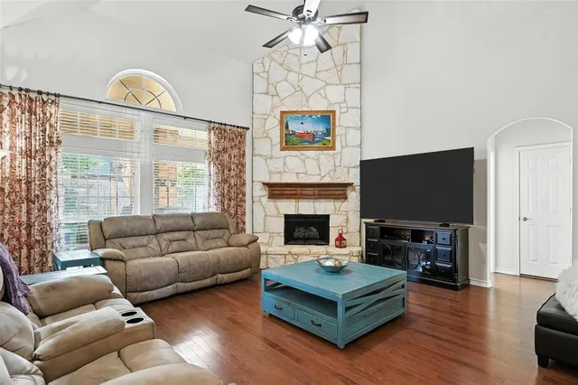 a living room with furniture a flat screen tv and a fireplace