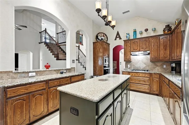 a kitchen with stainless steel appliances granite countertop a sink dishwasher and cabinets with wooden floor