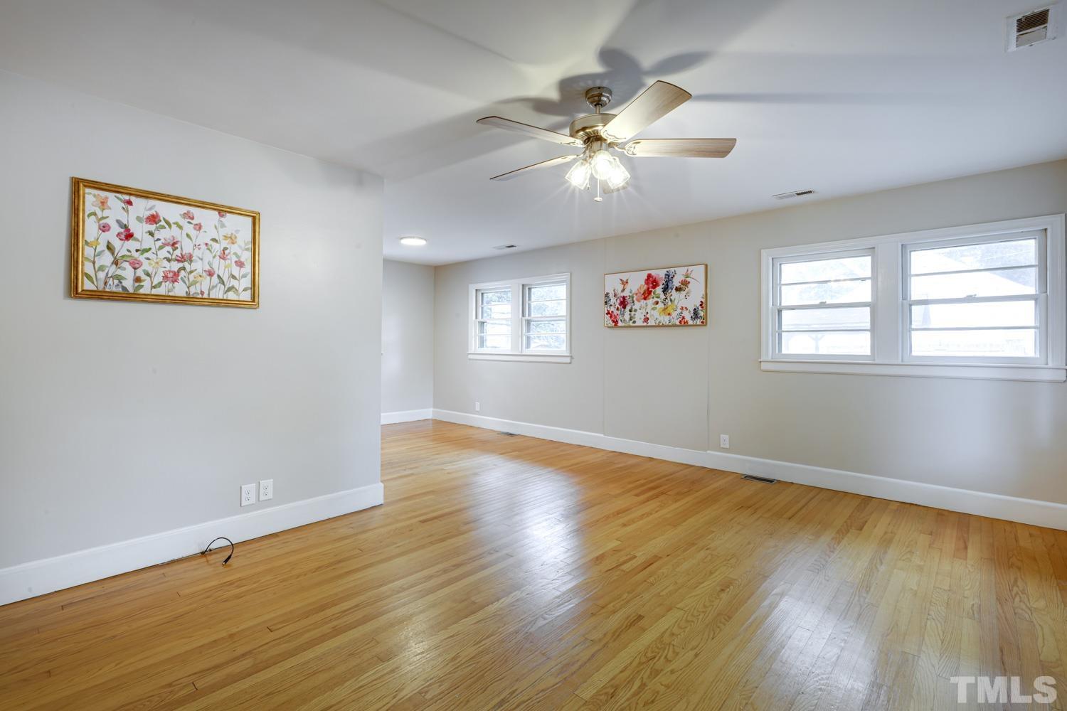 4008 Cheek Road Durham, NC 27704 - Photo 3 of 10 a view of an empty room with wooden floor and a window