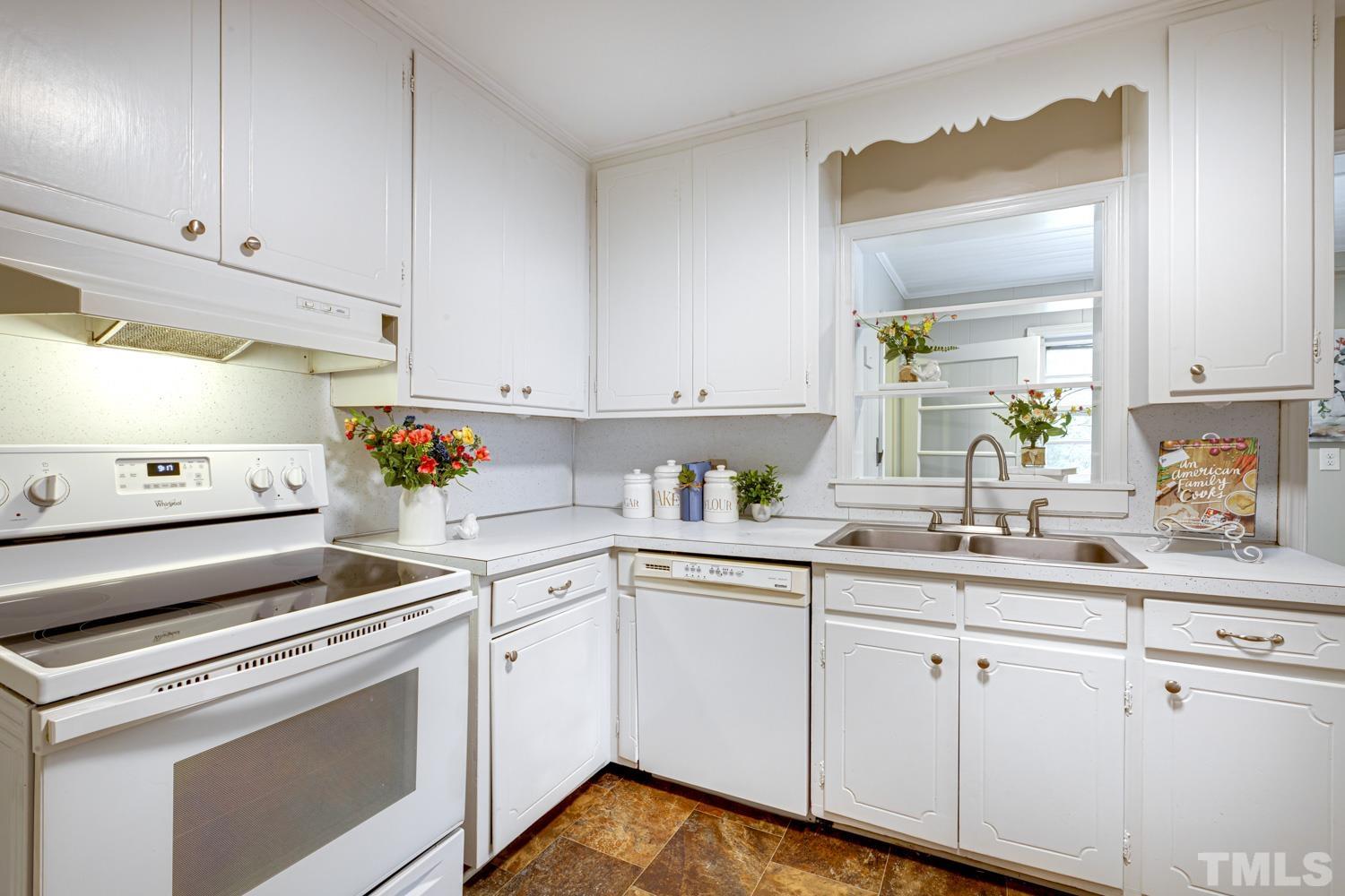 4008 Cheek Road Durham, NC 27704 - Photo 5 of 10 a kitchen with cabinets appliances a sink and a window