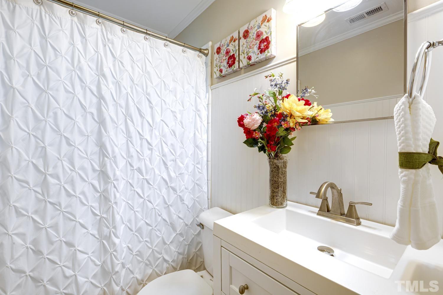4008 Cheek Road Durham, NC 27704 - Photo 8 of 10 a bathroom with a sink mirror and vanity
