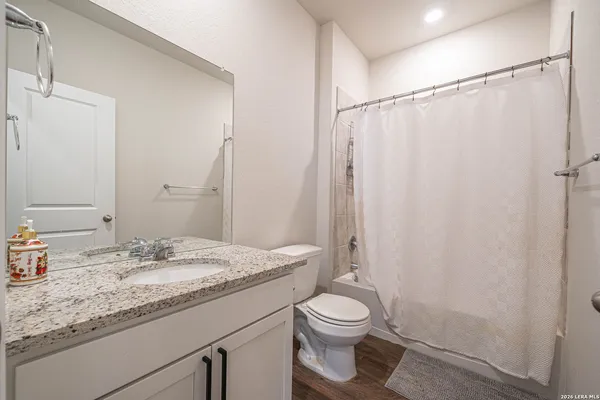a bathroom with a granite countertop sink toilet and shower