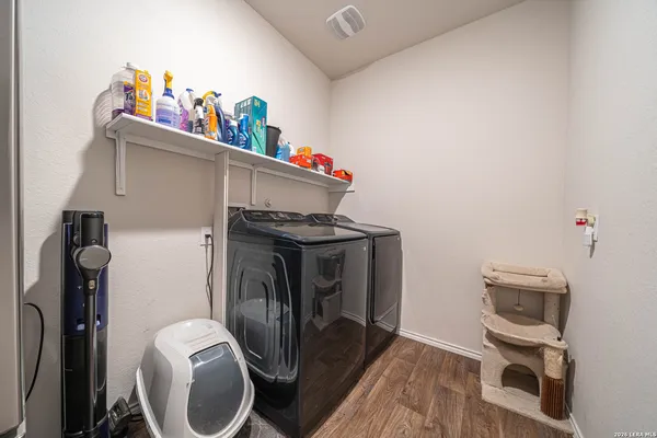 a utility room with dryer washer and a view of living room