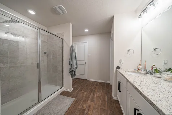 a bathroom with a granite countertop sink mirror and shower
