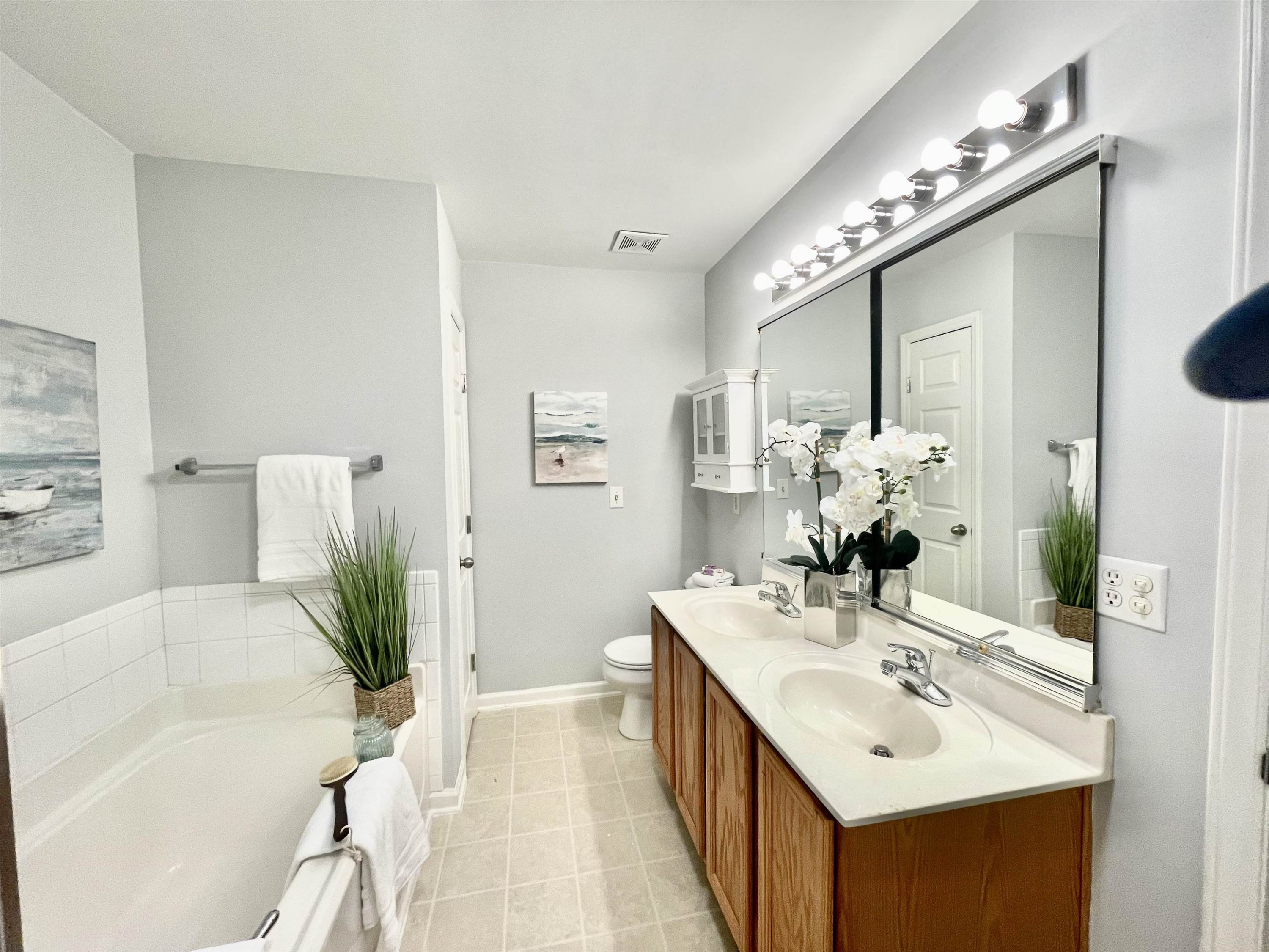 8621 Neuse Club Lane, Unit 109 Raleigh, NC 27616 - Photo 16 of 21 a bathroom with a tub sink and mirror