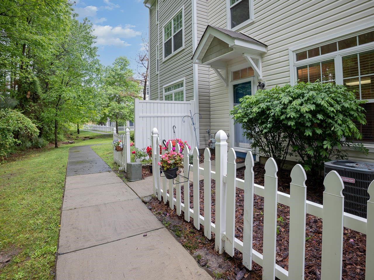8621 Neuse Club Lane, Unit 109 Raleigh, NC 27616 - Photo 3 of 21 a front view of house and yard with beautiful flowers and green space