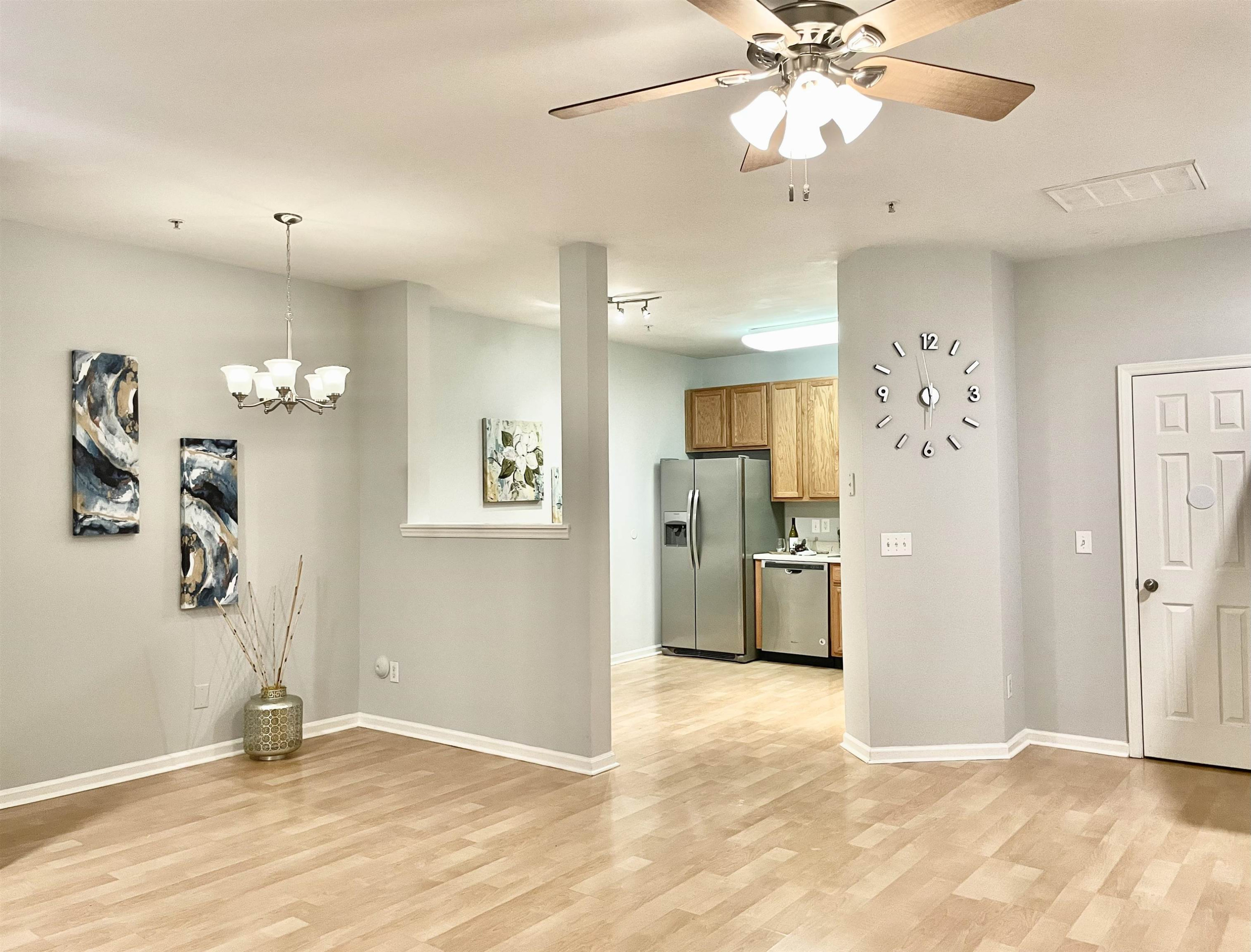 8621 Neuse Club Lane, Unit 109 Raleigh, NC 27616 - Photo 4 of 21 a view of a kitchen with a refrigerator cabinets and a wooden floor