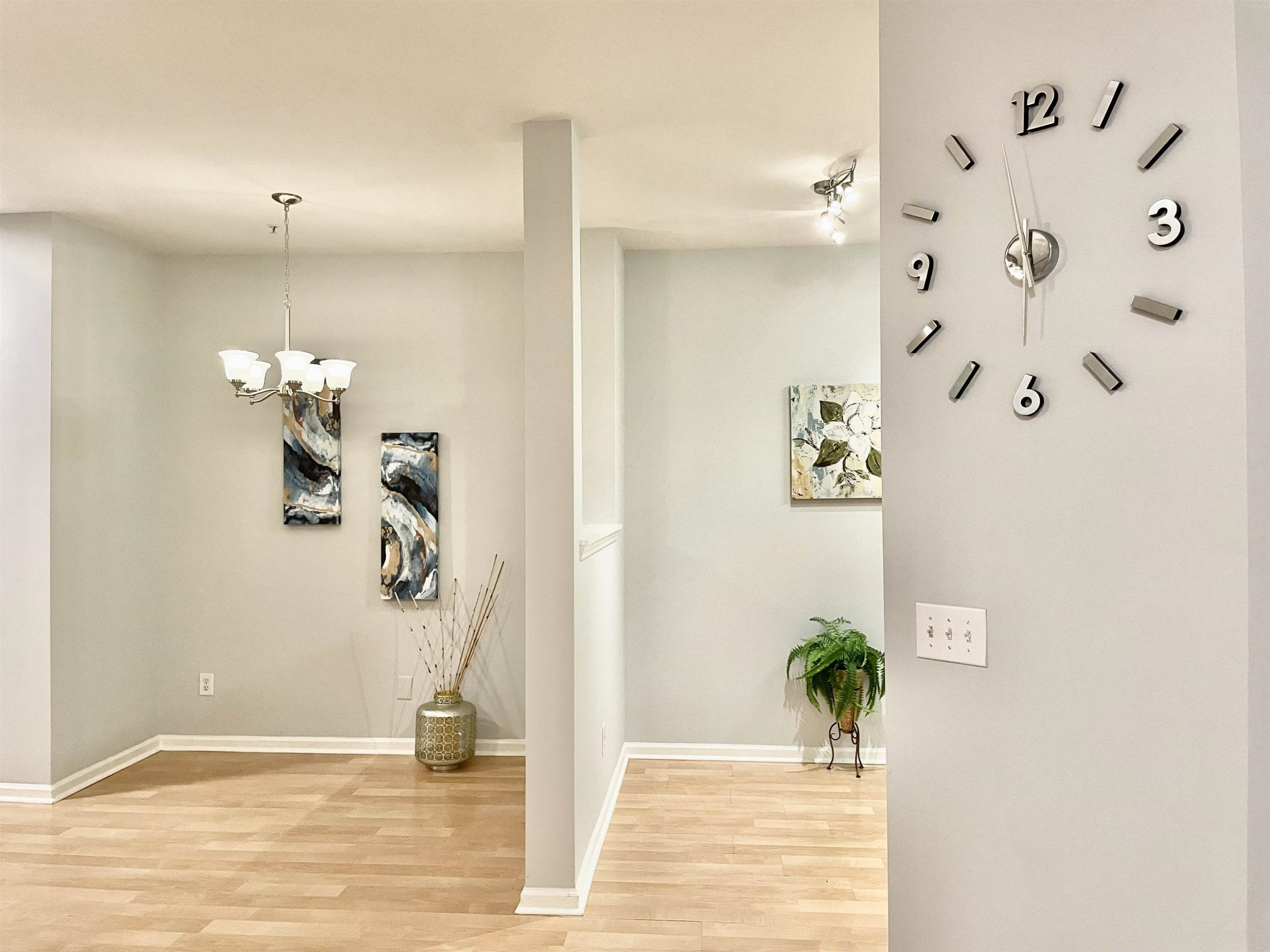 8621 Neuse Club Lane, Unit 109 Raleigh, NC 27616 - Photo 5 of 21 a view of a hallway with wooden floor and a potted plant