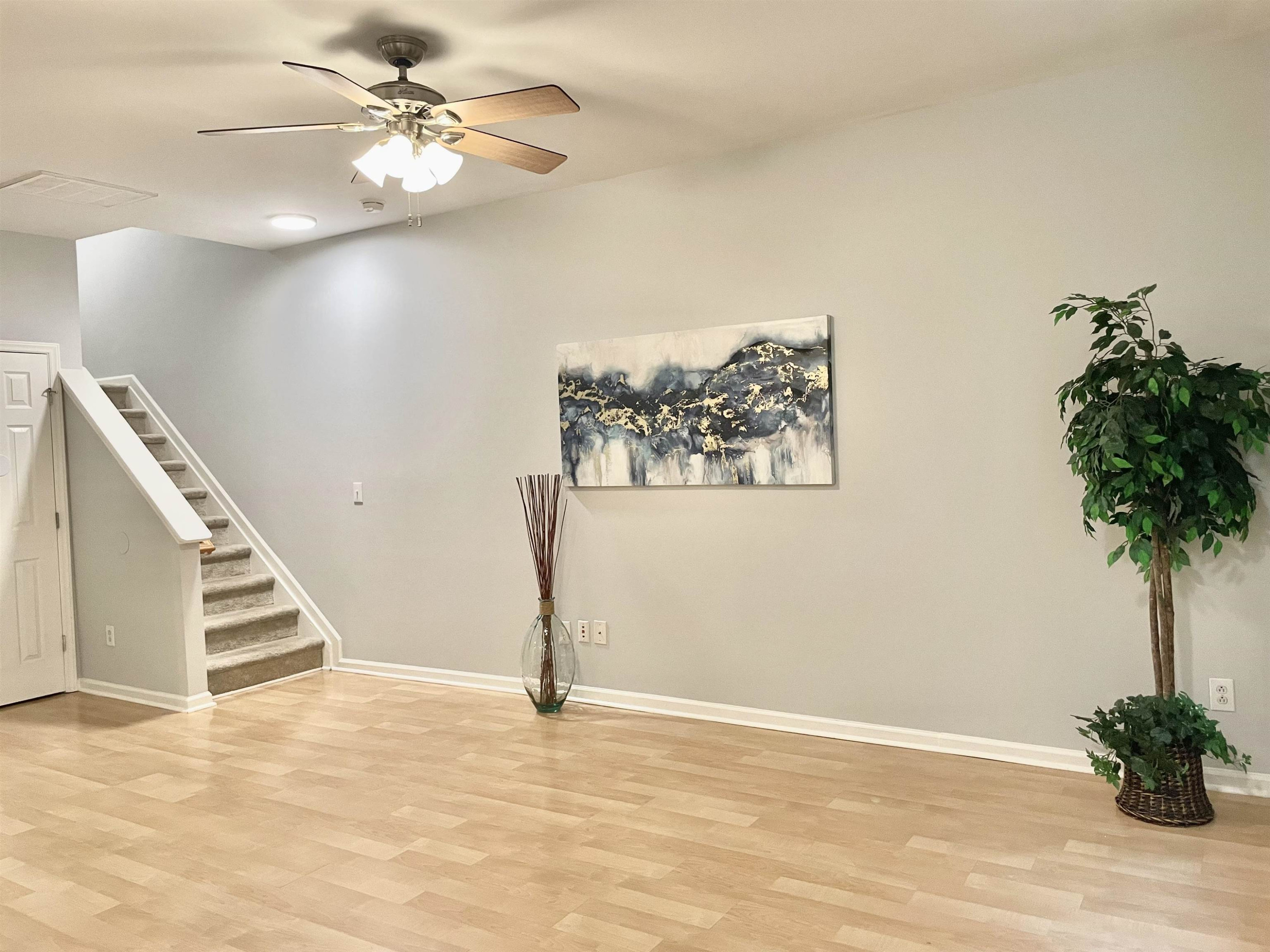 8621 Neuse Club Lane, Unit 109 Raleigh, NC 27616 - Photo 7 of 21 a view of a livingroom with a potted plant a ceiling fan and wooden floor