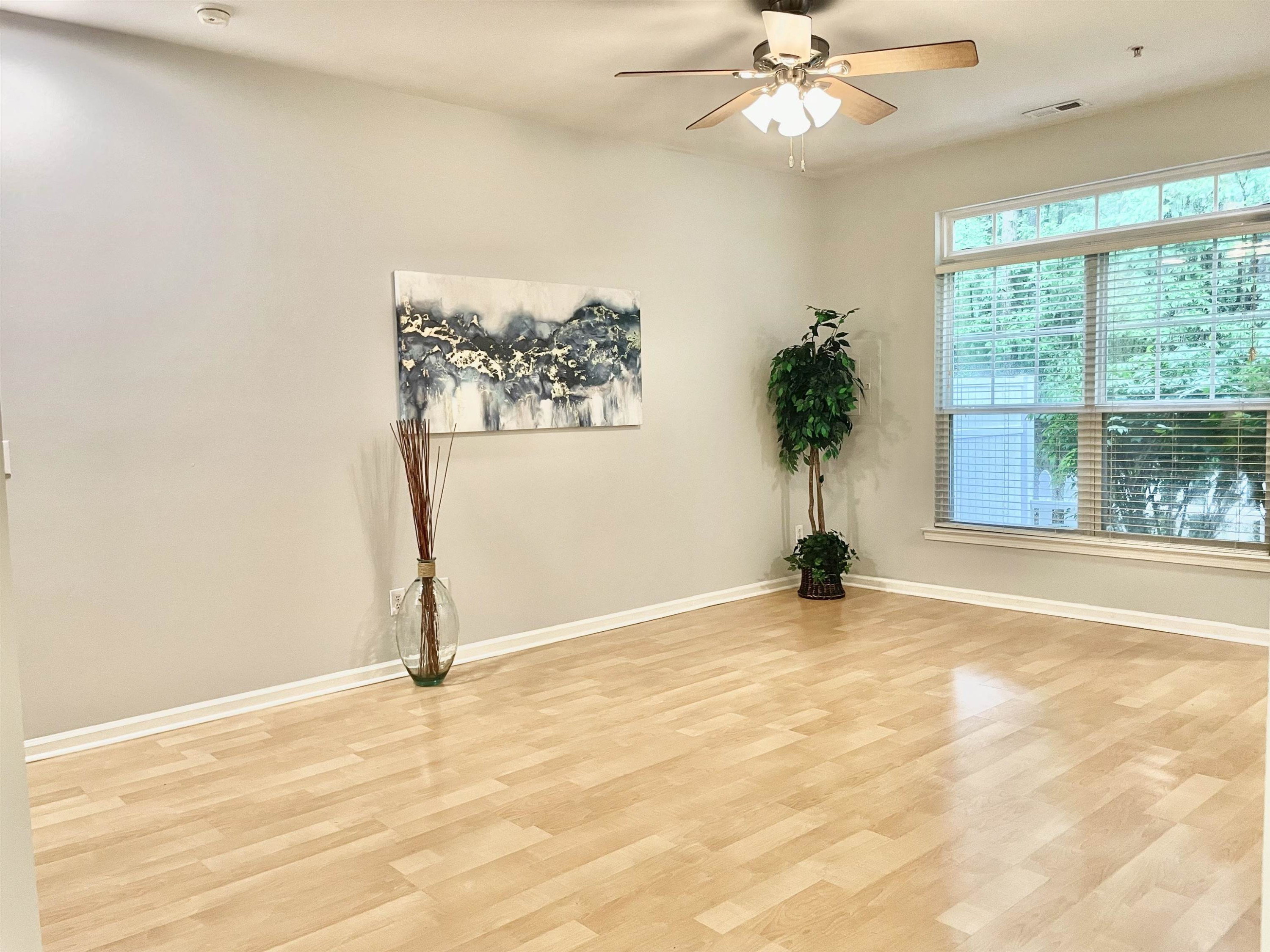 8621 Neuse Club Lane, Unit 109 Raleigh, NC 27616 - Photo 8 of 21 an empty room with windows and ceiling fan