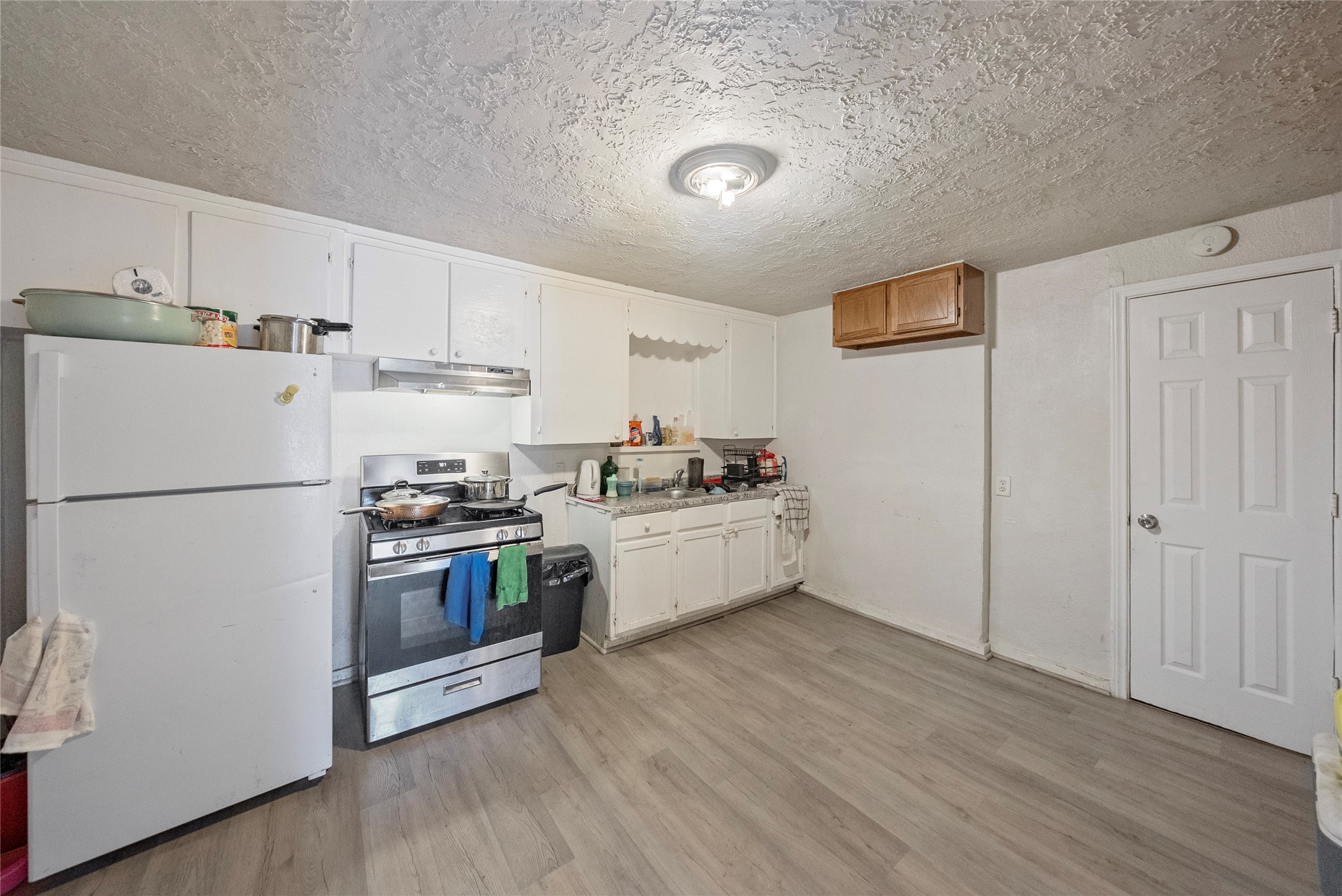 7938 Kerr Street, Unit 6 Houston, TX 77029 - Photo 6 of 18 a kitchen with stainless steel appliances a refrigerator sink and white cabinets