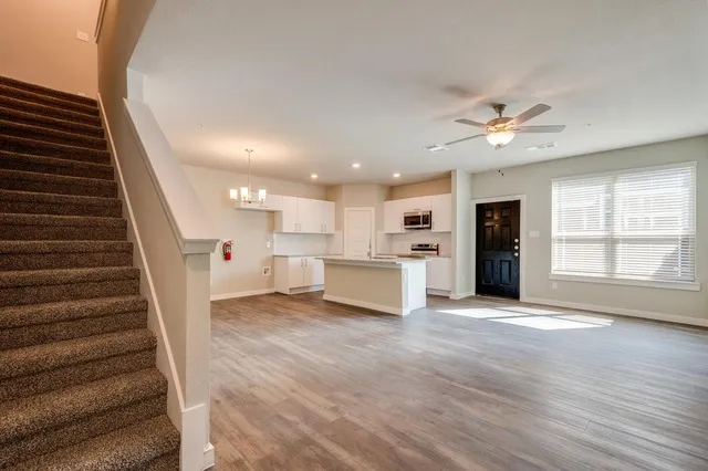 a view of a kitchen with wooden floor and staircase