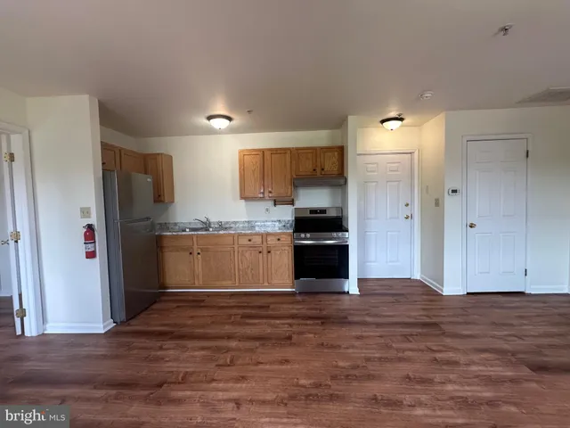 a kitchen with granite countertop a refrigerator and a sink