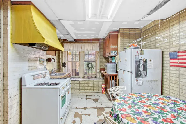 a backyard of a house with barbeque oven table and chairs