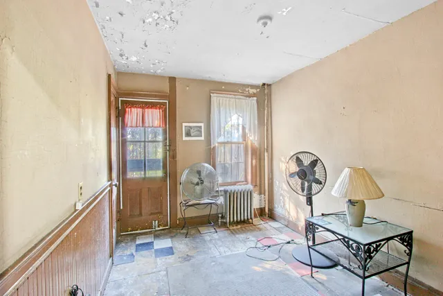 a front view of a house with a tree