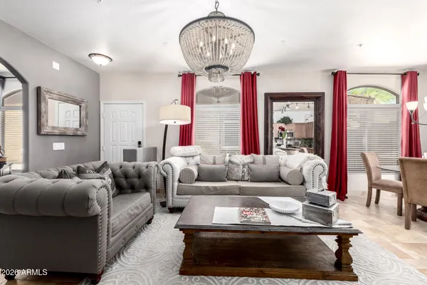 a living room with furniture a large window and a chandelier