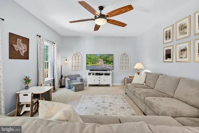 a living room with furniture ceiling fan and a window