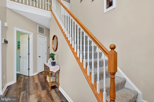 a view of a hallway with wooden floor and staircase