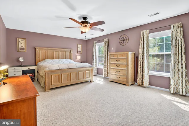 a bedroom with a bed a chandelier and dresser