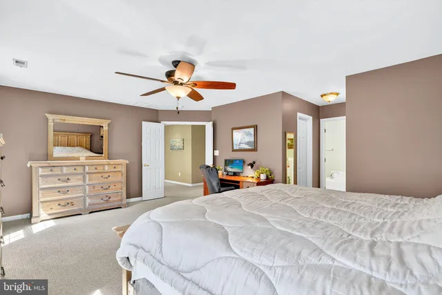 a bedroom with a large bed and a flat tv screen on dresser