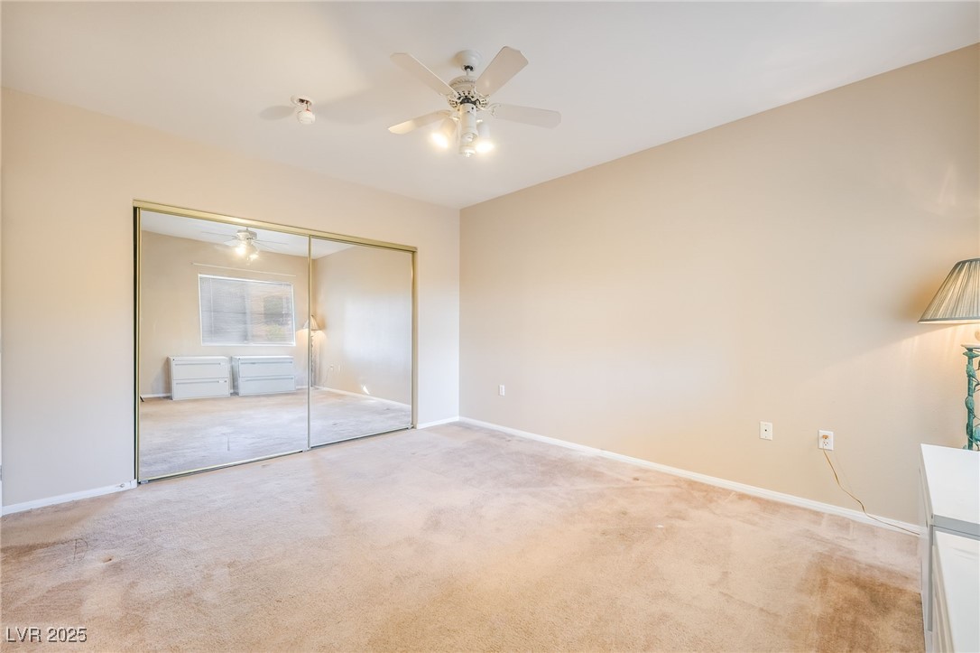 1509 Dallas Terrace, Unit 294 Henderson, NV 89014 - Photo 16 of 27 Unfurnished bedroom with light carpet, ceiling fan, and a closet