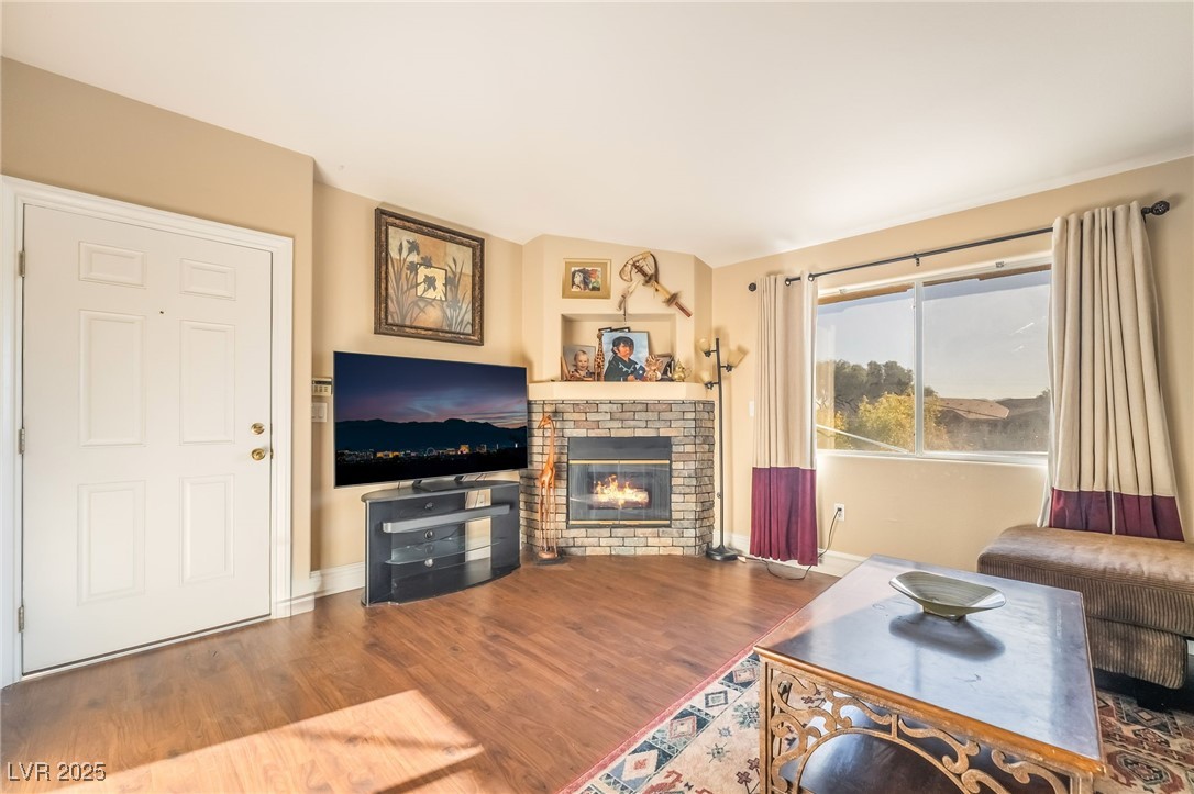 1509 Dallas Terrace, Unit 294 Henderson, NV 89014 - Photo 3 of 27 Living area featuring a brick fireplace and wood finished floors