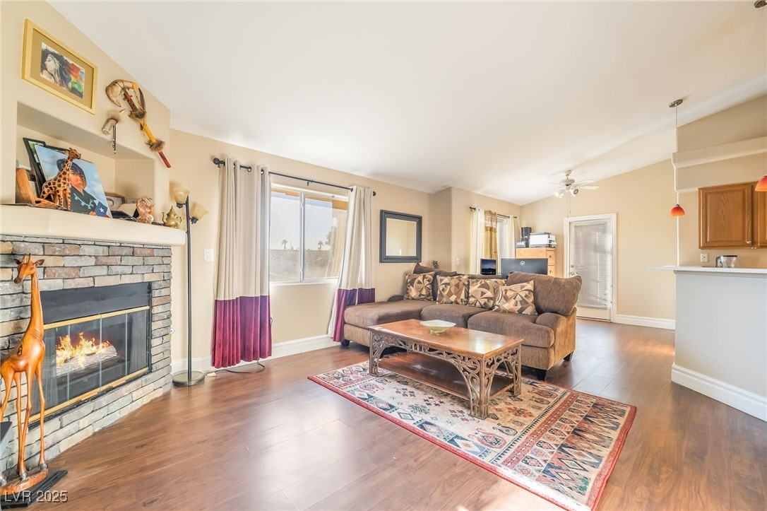 1509 Dallas Terrace, Unit 294 Henderson, NV 89014 - Photo 4 of 27 Living room featuring wood finished floors, a fireplace, vaulted ceiling, and ceiling fan