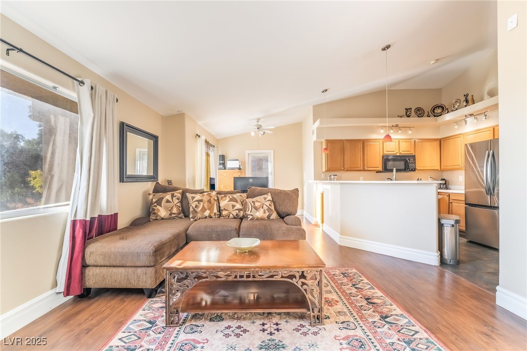 1509 Dallas Terrace, Unit 294 Henderson, NV 89014 - Photo 5 of 27 Living area with plenty of natural light, vaulted ceiling, a ceiling fan, and dark wood-style floors