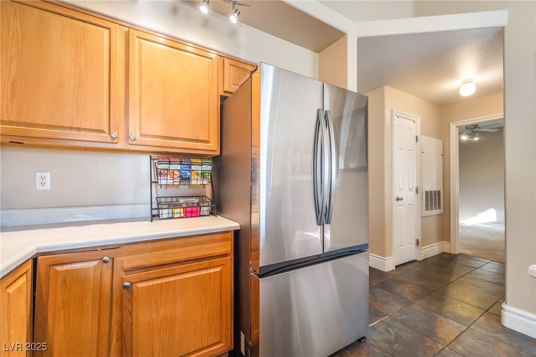 1509 Dallas Terrace, Unit 294 Henderson, NV 89014 - Photo 9 of 27 Kitchen featuring freestanding refrigerator, light countertops, and brown cabinets