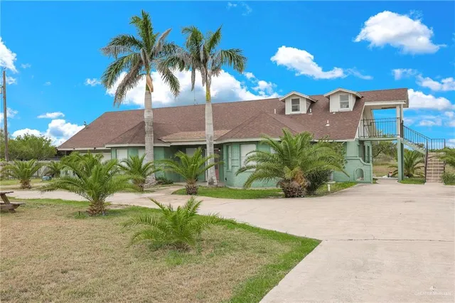 a view of a house with a yard and potted plants