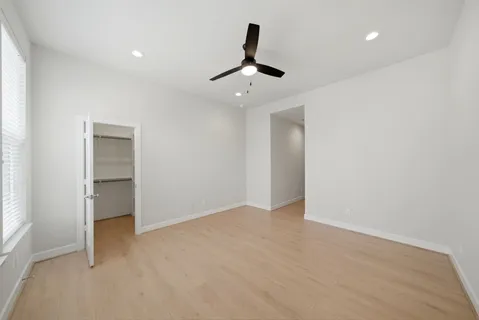 an empty room with ceiling fan and window