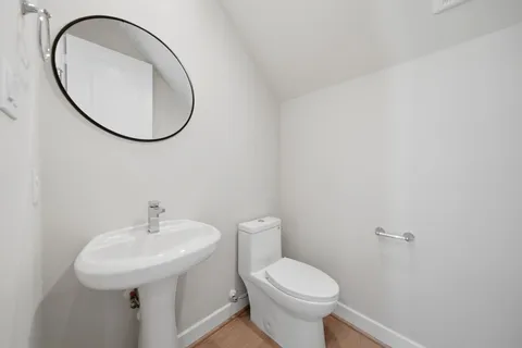 a bathroom with a sink a toilet and a mirror