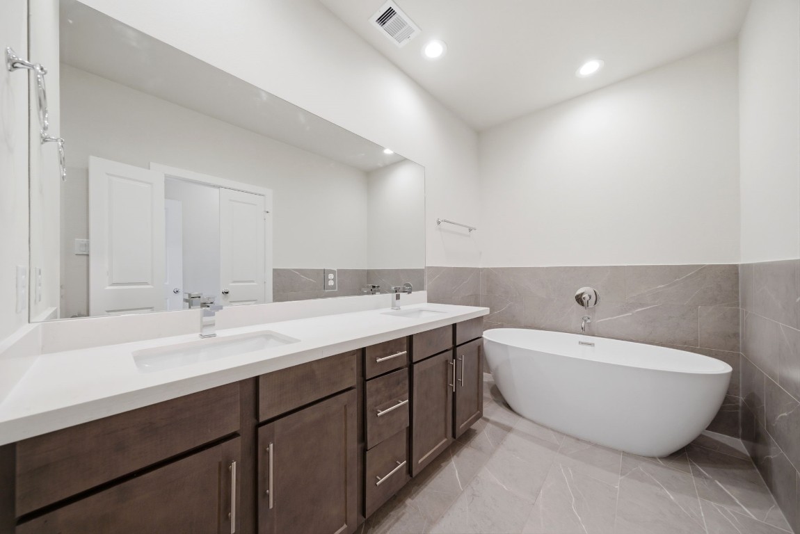 5906 Jasper Jones Way Houston, TX 77091 - Photo 18 of 22 a spacious bathroom with a double vanity sink mirror and bathtub